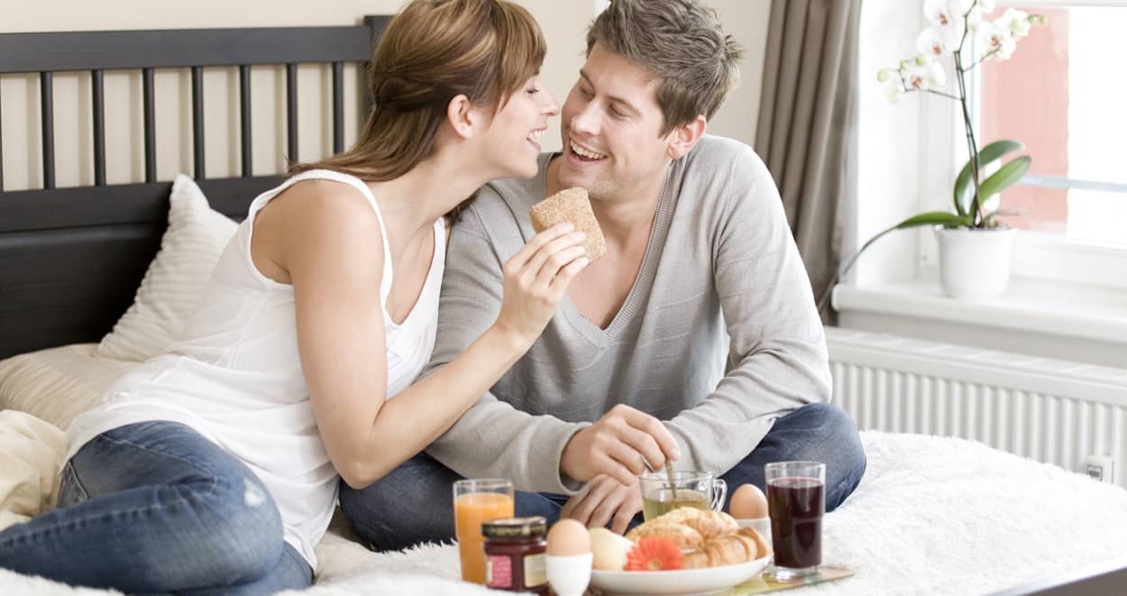 Paar bei einem romantischen Frühstück im Bett