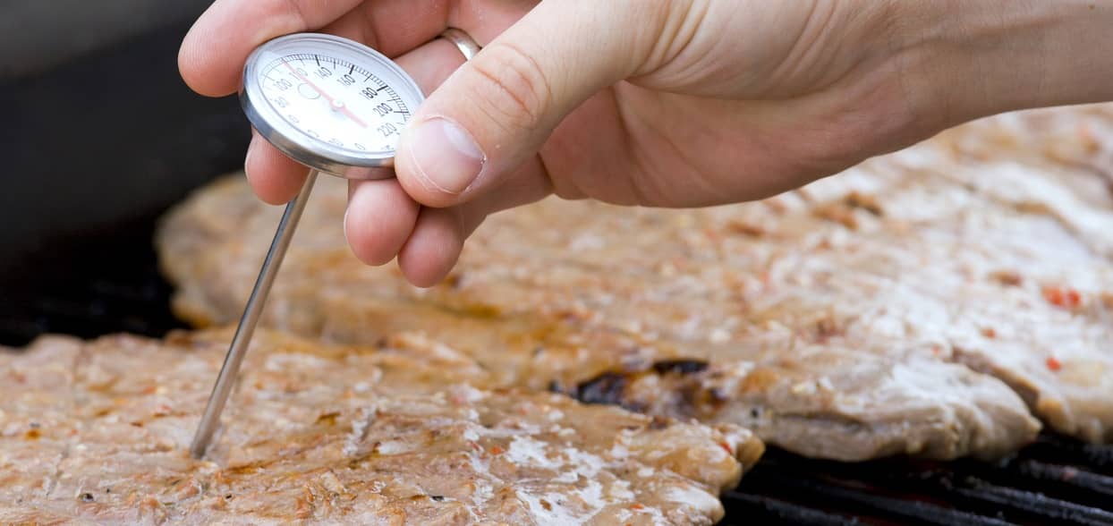 Koch überprüft mit dem Fleischthermometer die Kerntemperatur